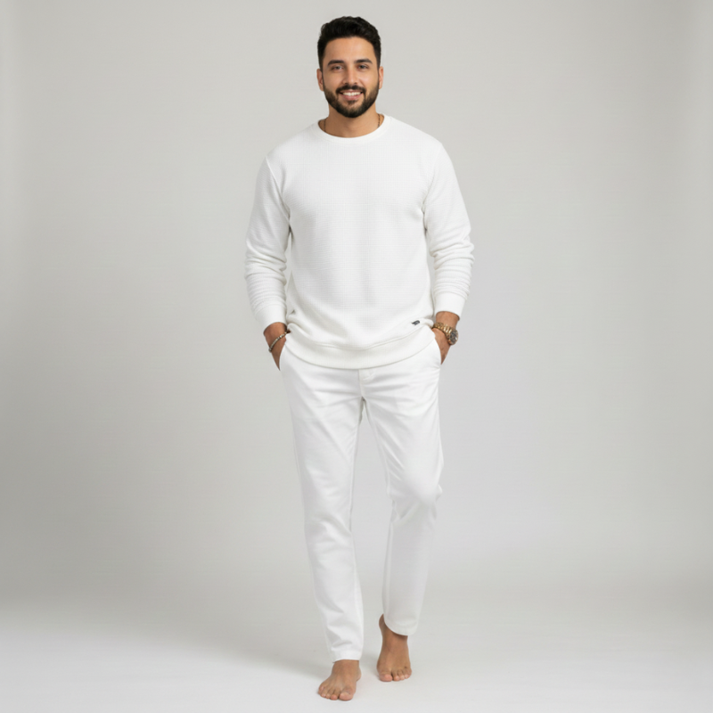 Man wearing a white outfit on a plain background