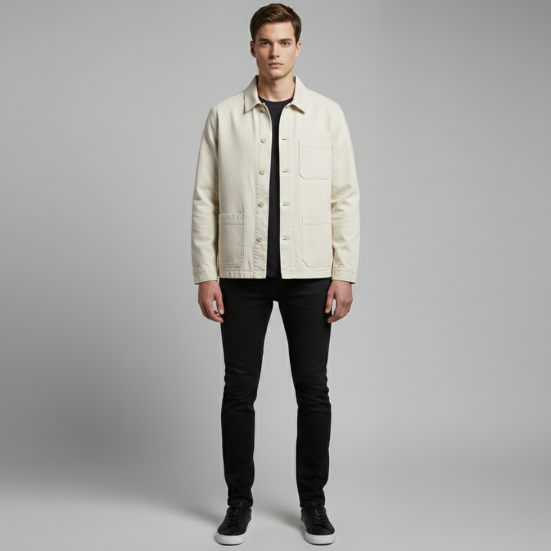 Man wearing a light-colored jacket over a black shirt and pants on a gray background