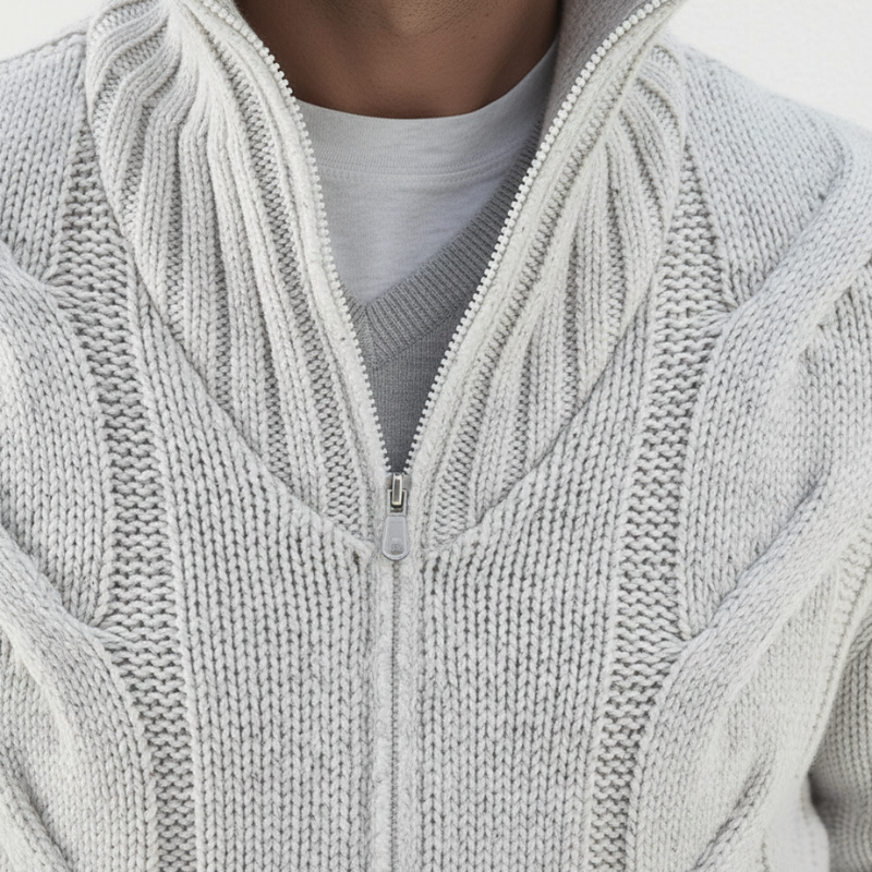 Close-up of a person wearing a light gray cable knit sweater with a zipper.