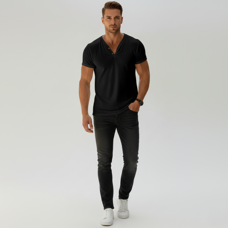 Man wearing a black V-neck shirt and black jeans on a white background