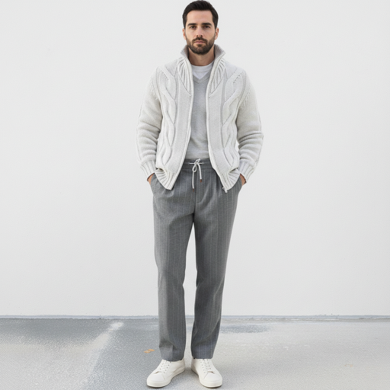 Man wearing a gray sweater and pants with a white background