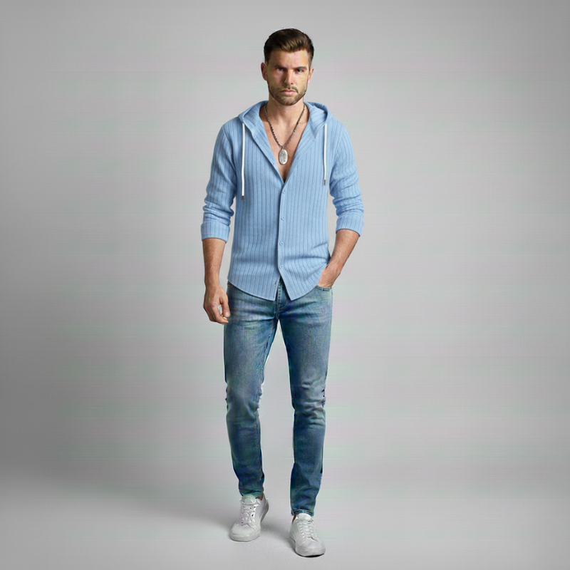 Man wearing a light blue hoodie and jeans on a gray background