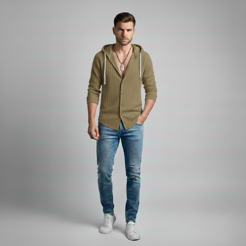 Man wearing a green cardigan, blue jeans, and white sneakers on a gray background