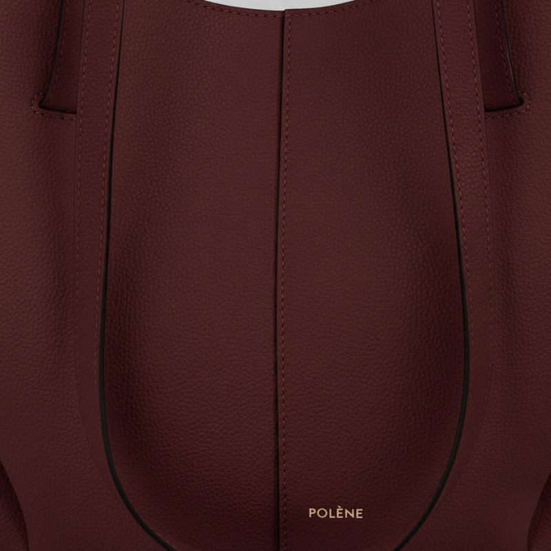 Close-up of a burgundy handbag with visible stitching and 'Polene' branding.