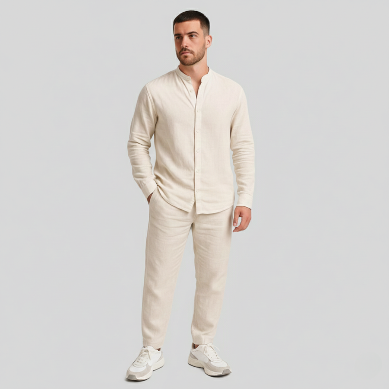 Man wearing a beige suit with white sneakers on a light gray background