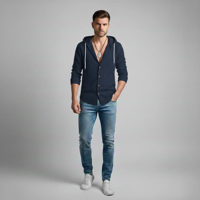 Man wearing a navy blue hoodie and jeans on a gray background