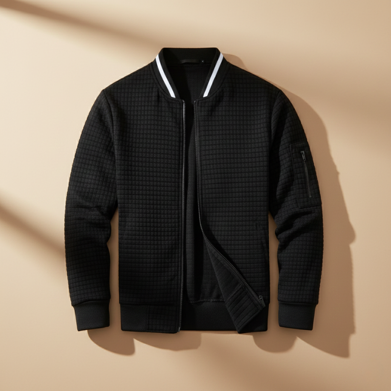 Black quilted jacket with white trim on a beige background