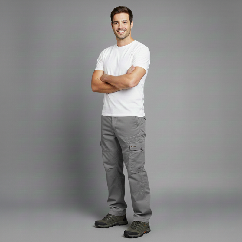 Man wearing a white t-shirt and gray pants standing against a gray background