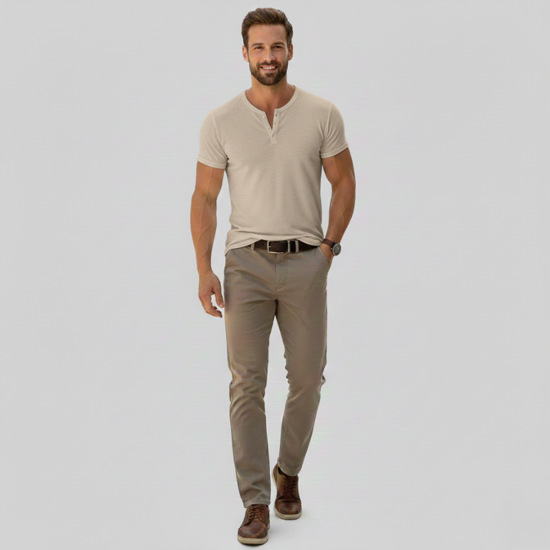 Man wearing a beige henley shirt and pants on a light gray background