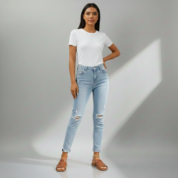 Woman wearing light blue jeans and a white t-shirt on a gray background