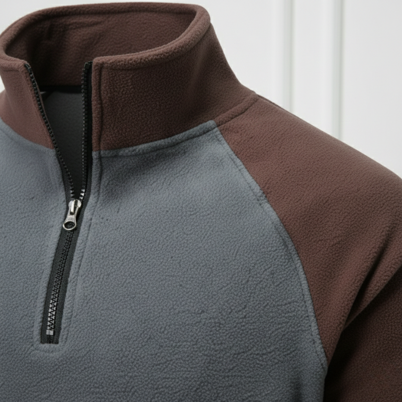 Close-up of a gray and brown fleece jacket with a zipper.
