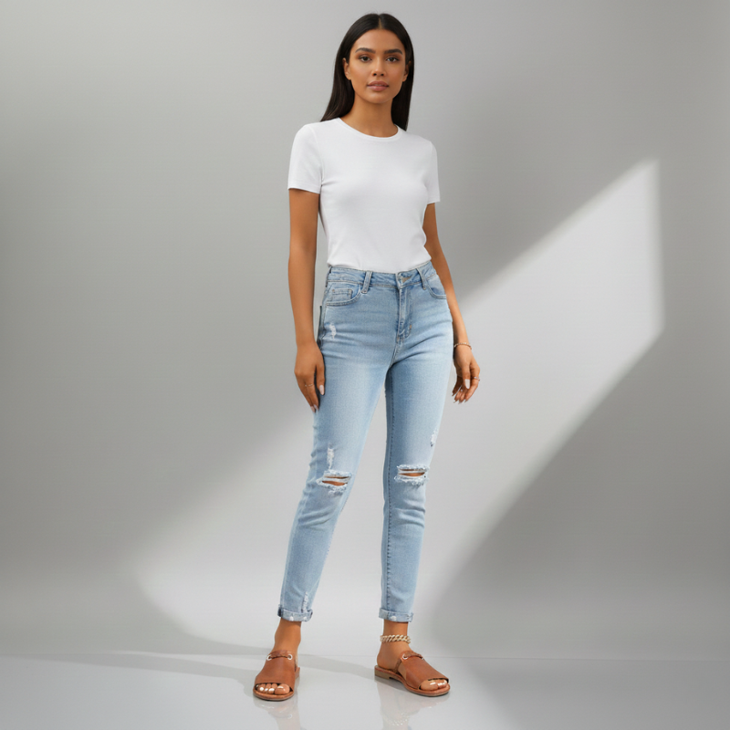 Woman wearing light blue jeans and a white t-shirt on a gray background