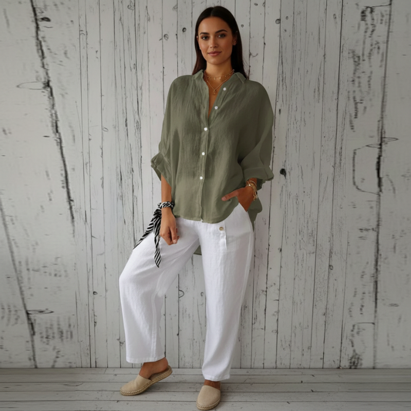 Woman wearing a green shirt and white pants against a wooden background