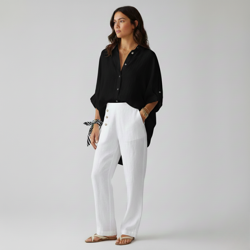 Woman wearing a black shirt and white pants on a plain background