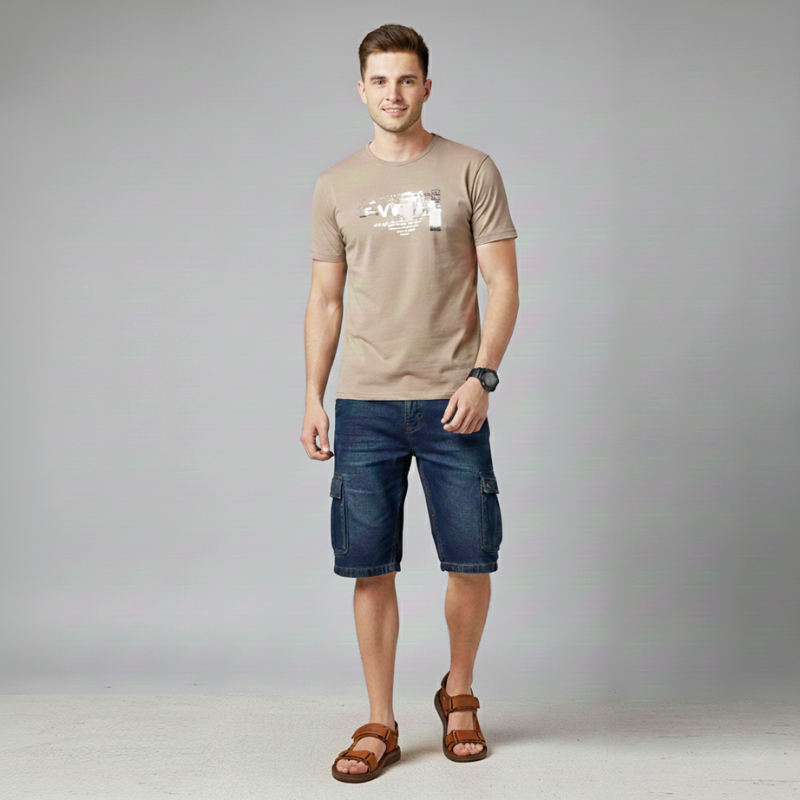 Man posing in brown casual sandals paired with blue shorts and a light t-shirt.