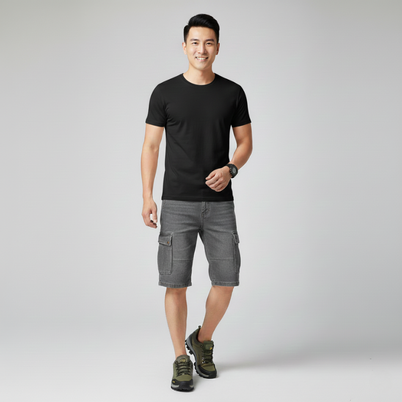 Male model wearing hiking shoes with a teal t-shirt and dark pants in studio lighting.