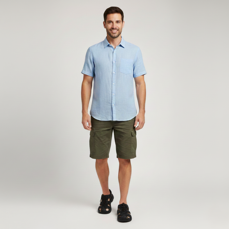 Male model standing in a light blue button-up shirt paired with olive green shorts.