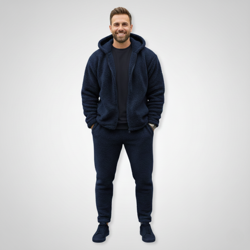 Male model wearing a navy fleece jacket paired with jeans in studio lighting.