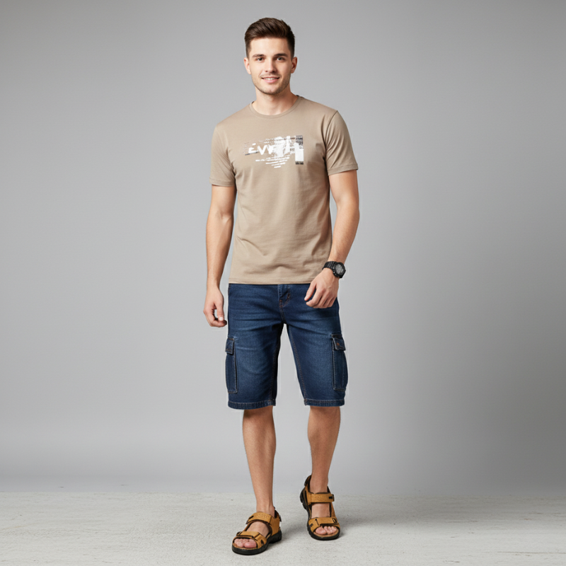 Male model wearing casual sandals with denim shorts and a neutral t-shirt in a studio setting.