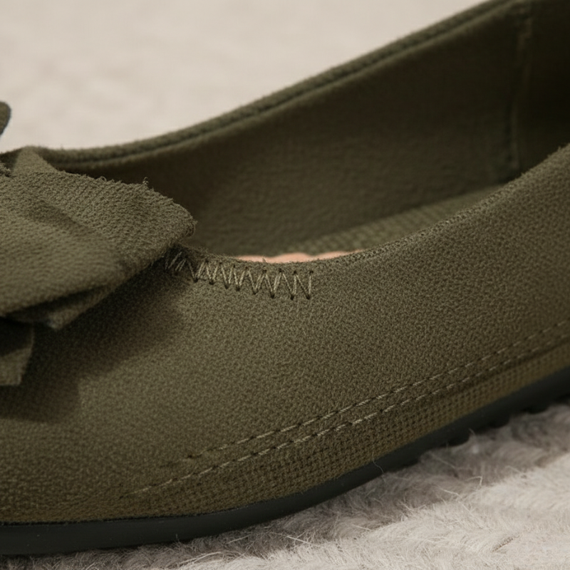 Green loafer shoe with a bow on a textured surface