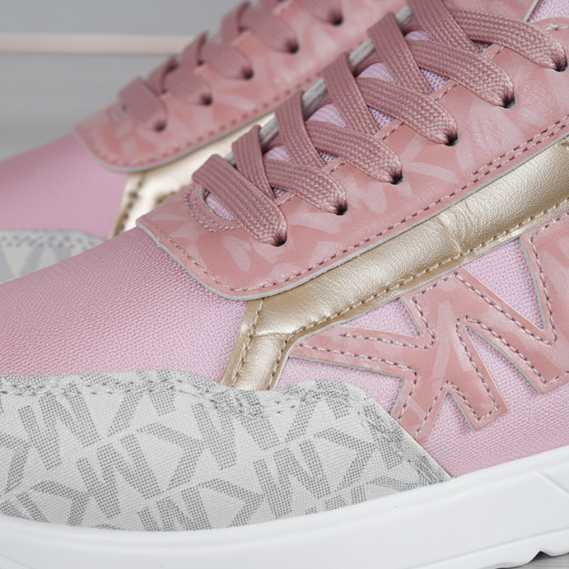 Close-up of pink sneakers with gold accents on a light gray background