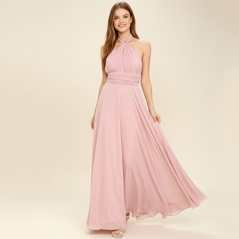 Woman wearing a pink chiffon maxi dress posing with a flowing skirt.