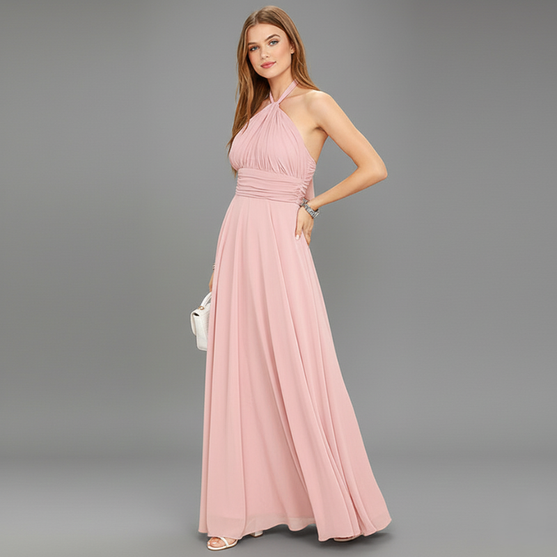 Model standing sideways wearing a pink chiffon maxi dress.