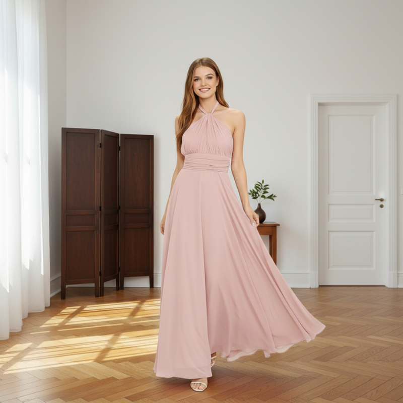 Woman wearing a flowing pink maxi dress in a bright indoor room.