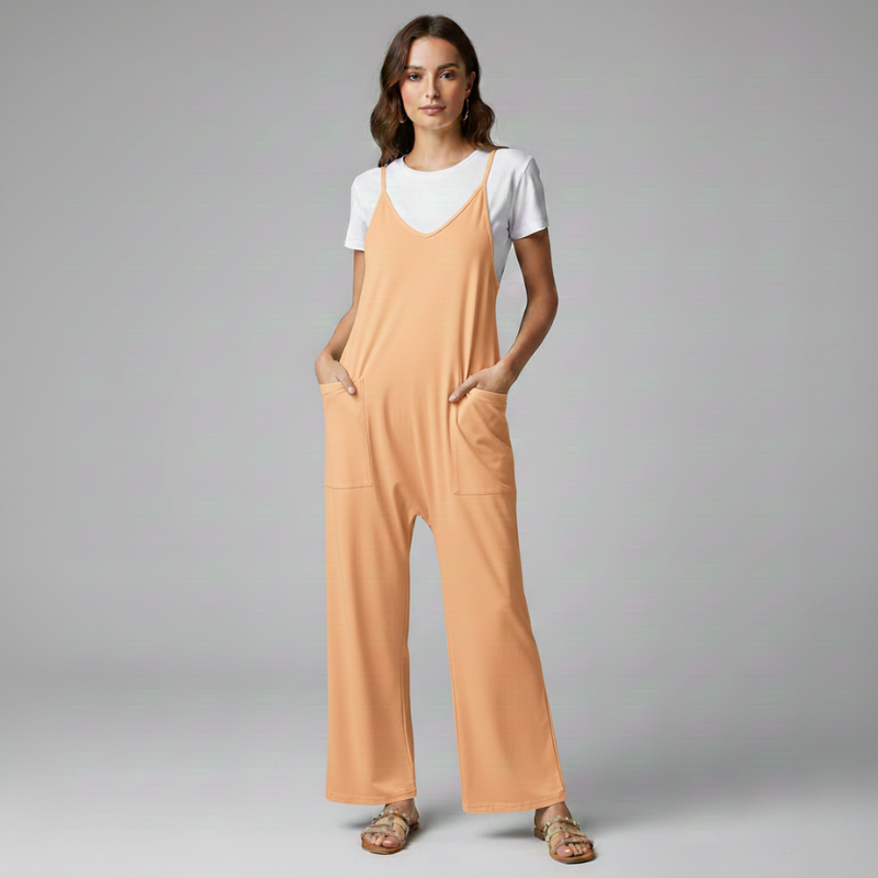 Woman wearing a peach-colored jumpsuit over a white shirt on a gray background