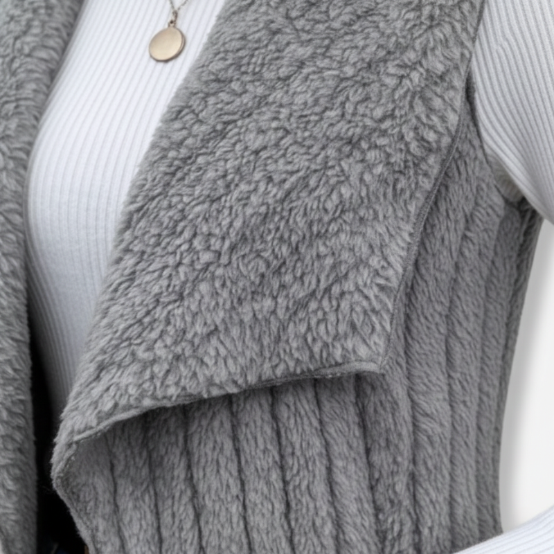 Gray textured sweater draped over a white surface