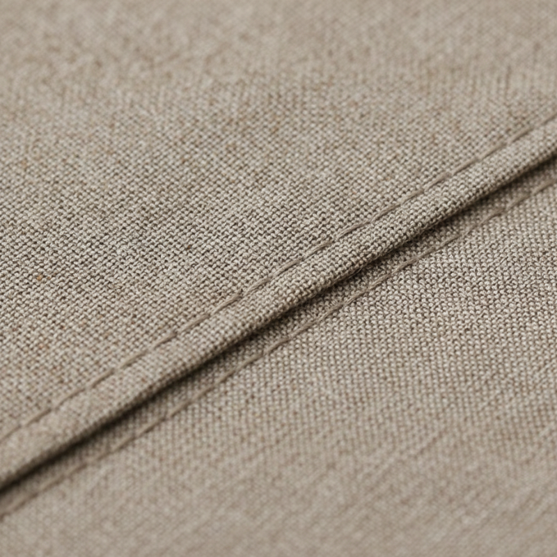 Close-up of beige fabric with a visible seam