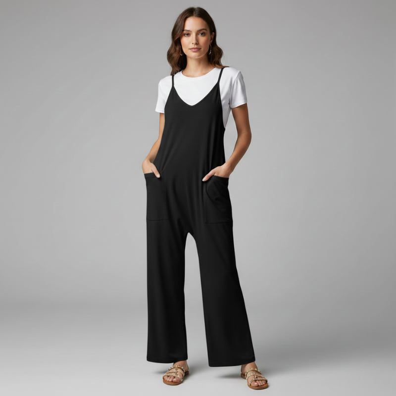 Woman wearing a black jumpsuit over a white shirt on a gray background