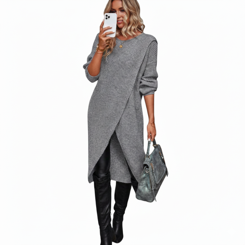 Woman wearing a gray sweater dress with black boots and holding a matching handbag on a white background