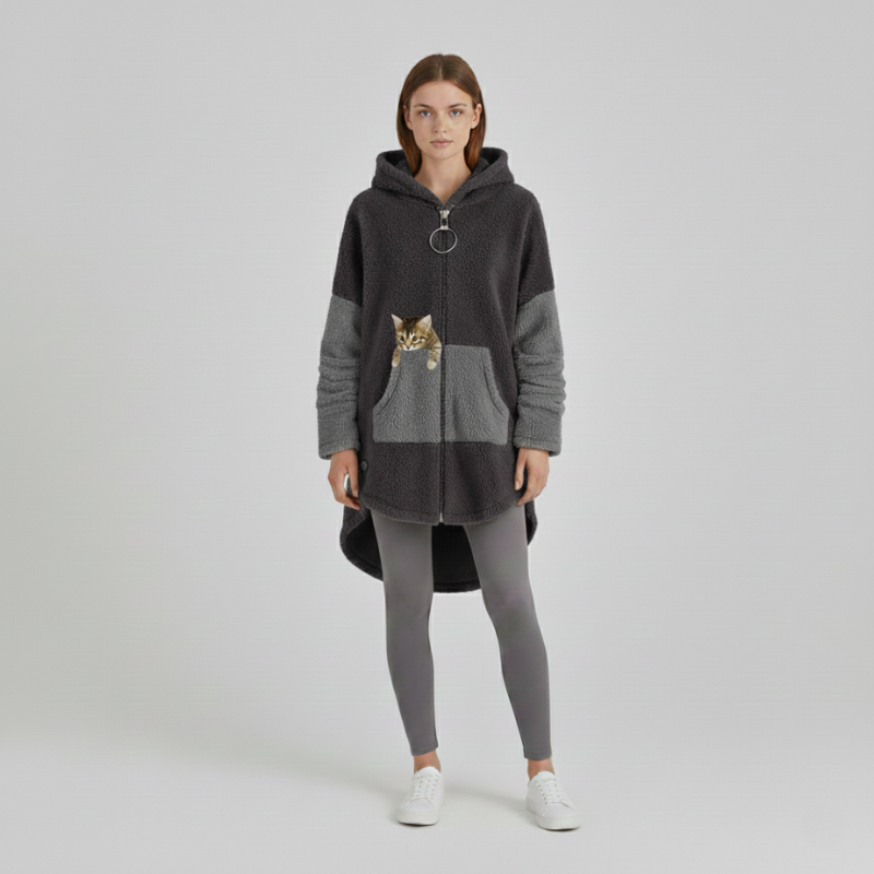 Woman wearing a gray hoodie with a cat design on a plain background