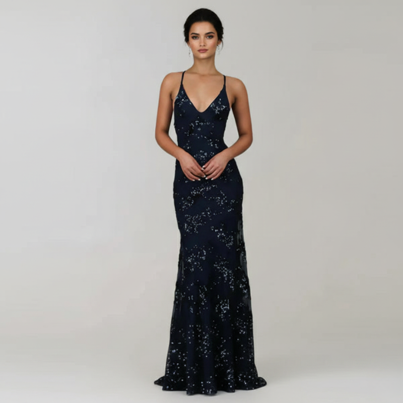 Woman wearing a navy blue sequin evening gown on a plain background