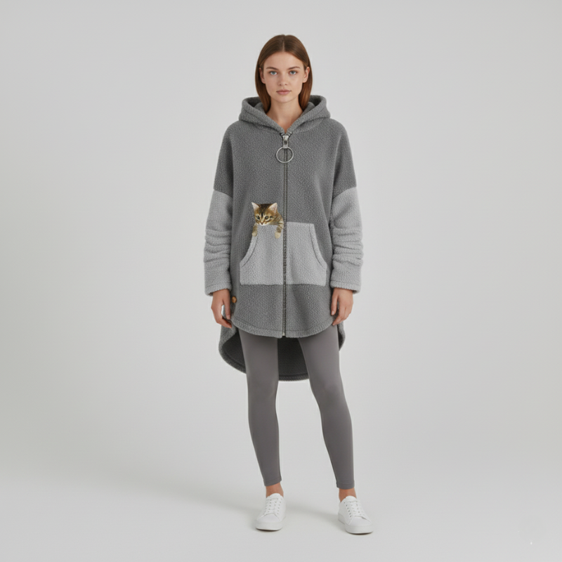 Woman wearing a gray hoodie with a cat design on a plain background