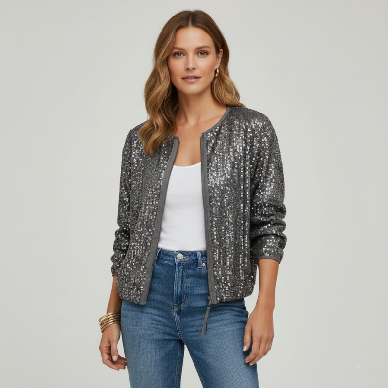 Woman wearing a sequin jacket over a white top and blue jeans on a plain background