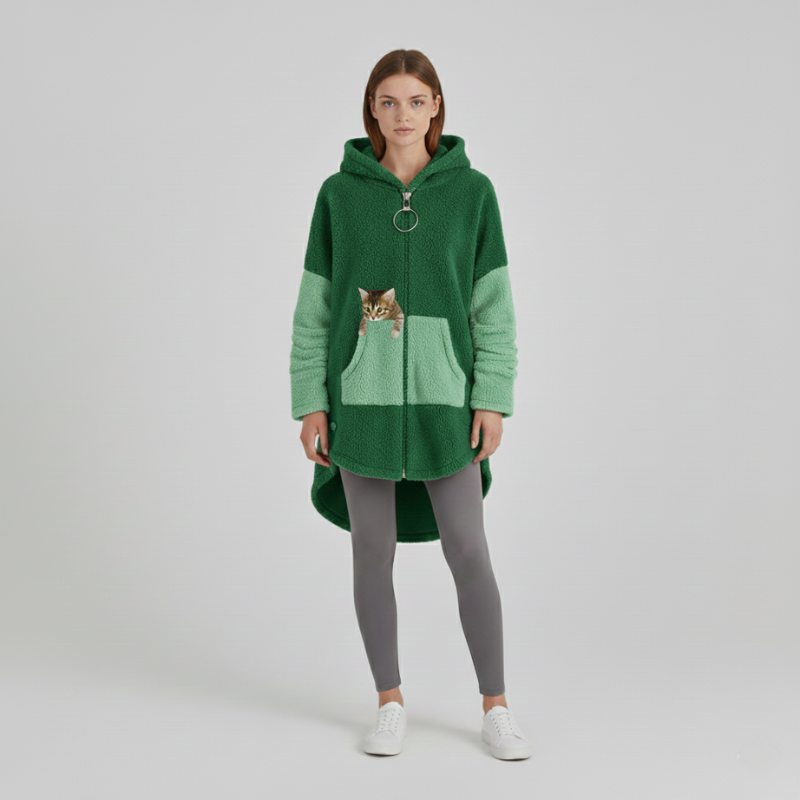 Person wearing a green hoodie with a cat design on a plain background