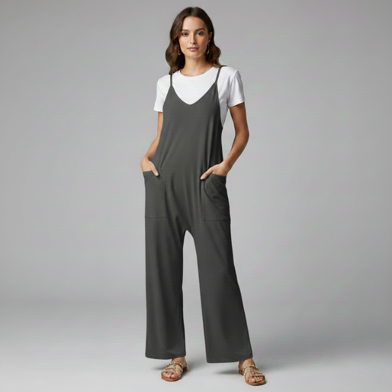 Woman wearing a gray jumpsuit over a white shirt on a gray background