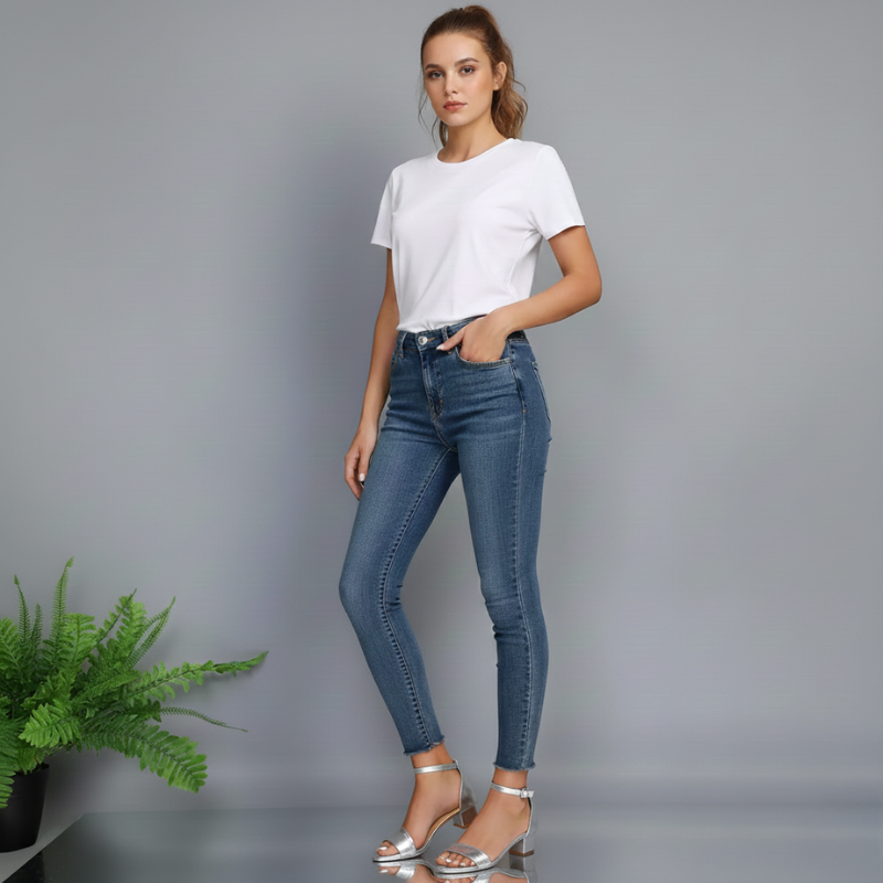 Woman wearing blue jeans and a white t-shirt on a gray background