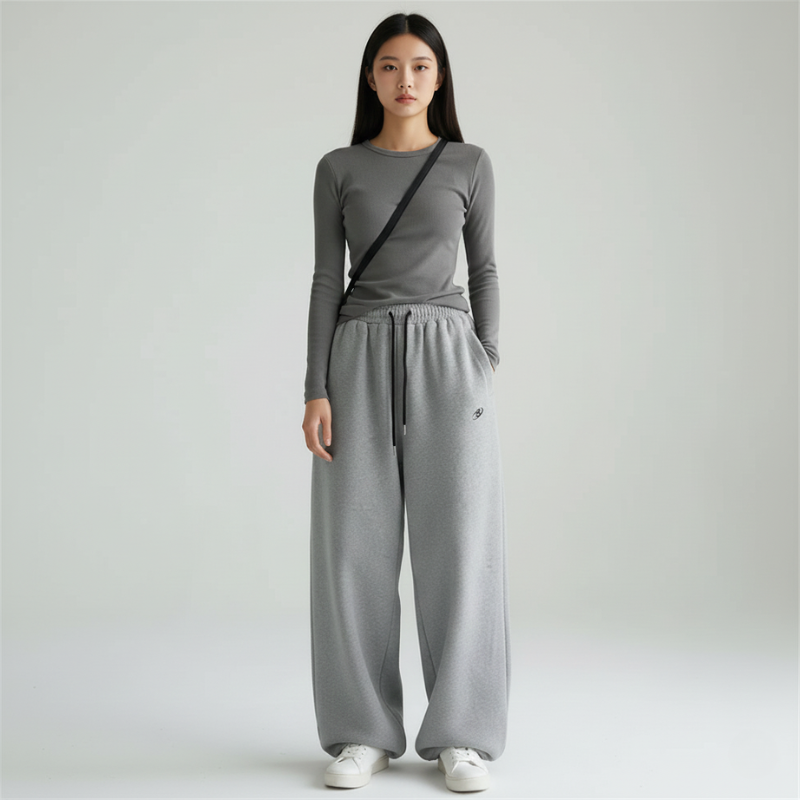 Full-body studio image of a woman wearing a relaxed fit gray knit top and pants set.