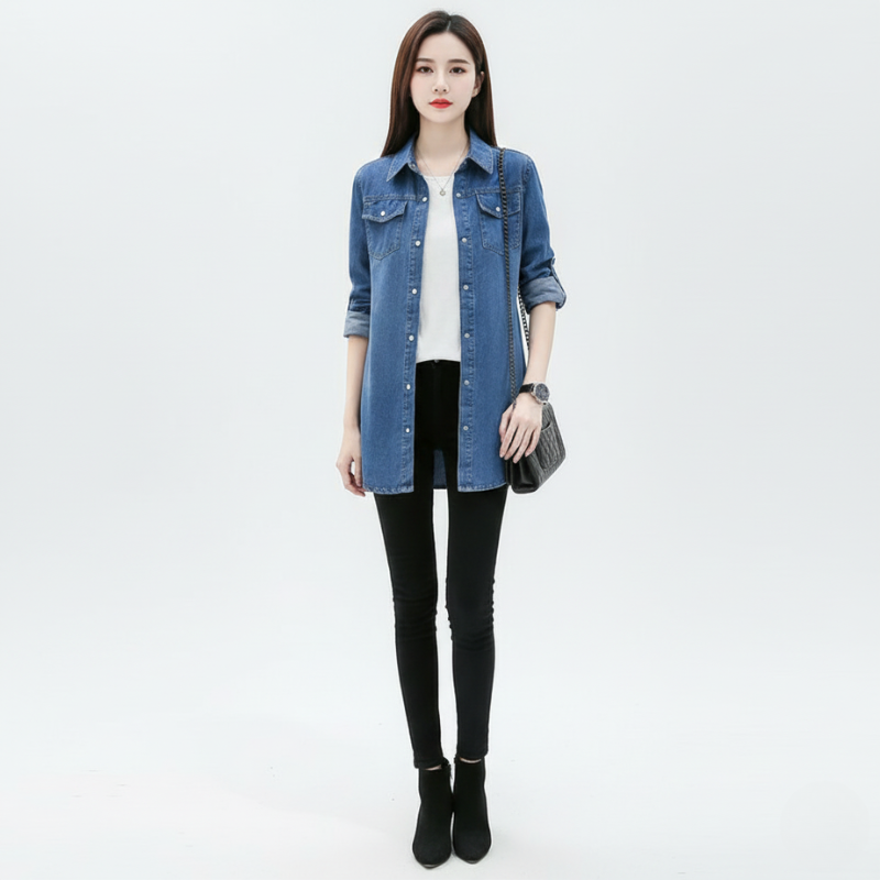 Woman wearing a blue denim jacket over a white shirt with black pants on a light gray background